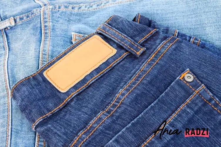 Złożone jeansy na stole, a także informacje, jak prać jeansy krok po kroku, sposoby, środki piorące, jak prać jeansy, żeby nie farbowały