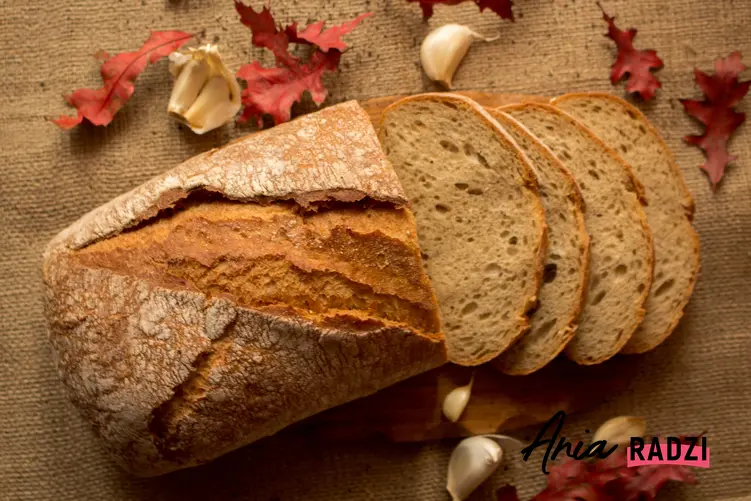 Pokrojony chleb na drewnianej desce oraz domowe sposoby jak odświeżyć chleb