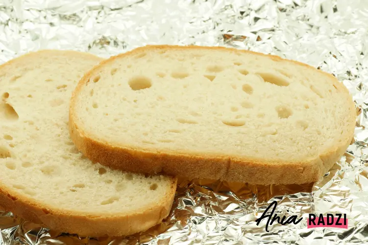 Kromki chleba leżące na folii aluminiowej oraz porady, jak odświeżyć chleb i inne pieczywo