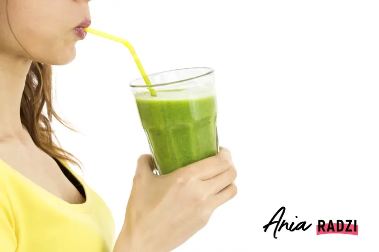 Młoda kobieta pijąca zielone smoothie przez słomkę i inne sposoby na odtrucie organizmu