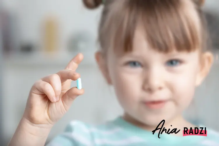 Dziewczynka trzymająca w dłoni lek na odrobaczenie, czyli porady jak odrobaczyć dziecko