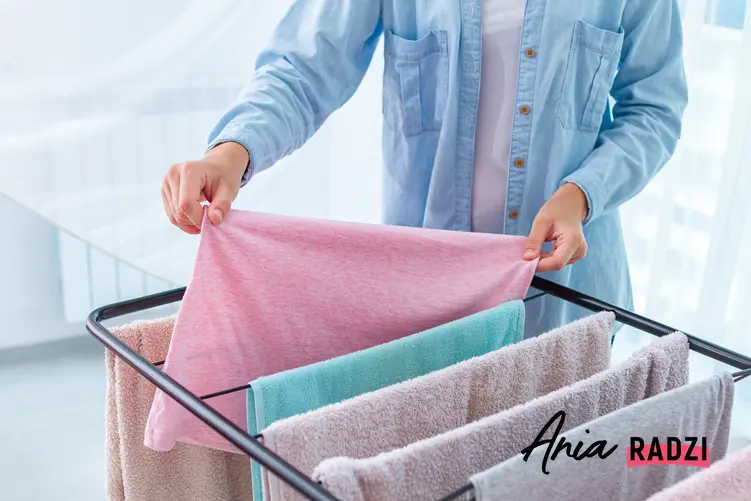 Kobieta wieszająca pranie na suszarce, a także polecana stojąca suszarka na pranie