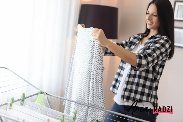 Kobieta wieszająca pranie na suszarce, a także polecana rozsuwana suszarka na pranie