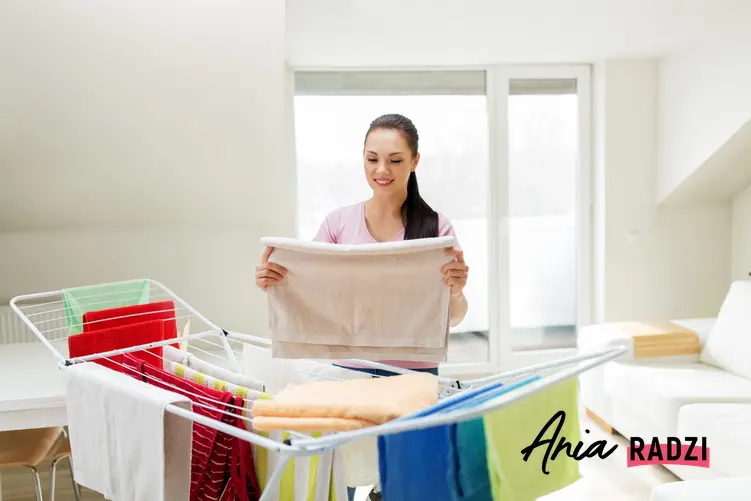 Kobieta wieszająca pranie na rozkładanej suszarce, a także suszarka na pranie vileda