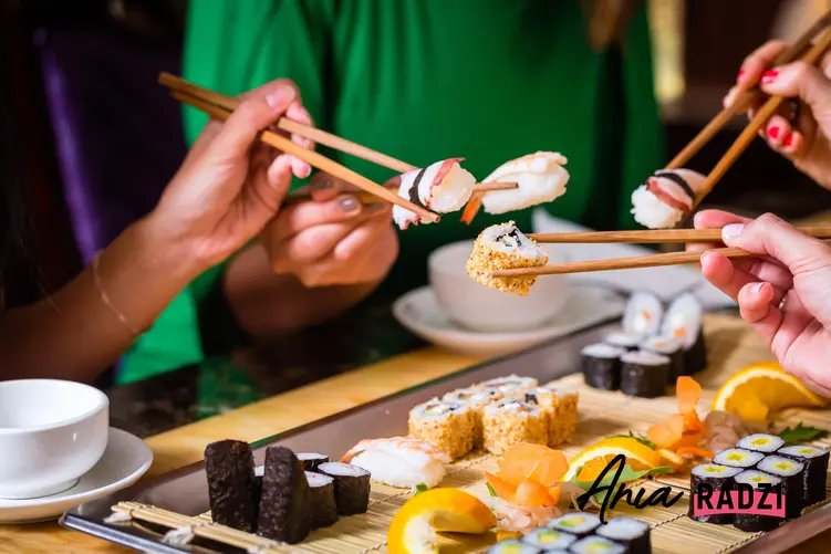 Spotkanie znajomych przy jedzeniu sushi i porady, jak trzymać pałeczki do sushi