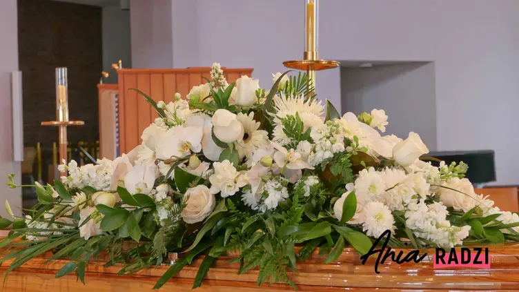 Wiązanka pogrzebowa z białych róż leżąca na trumnie, a także podpowiedzi, jakie wiązanki pogrzebowe wybrać, ich rodzaje oraz ceny