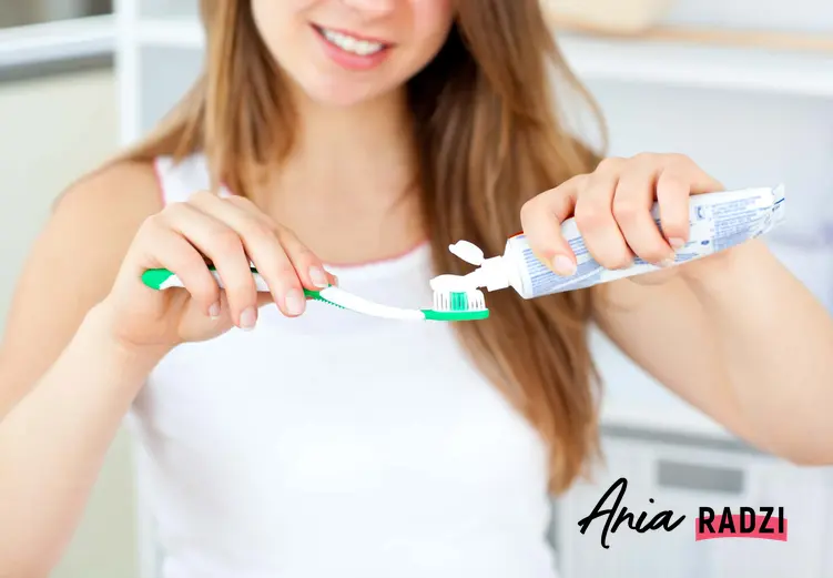 Dziewczyna nakładająca pastę do zębów na szczoteczkę, a także jak usunąć kamień nazębny, najlepsze sposoby