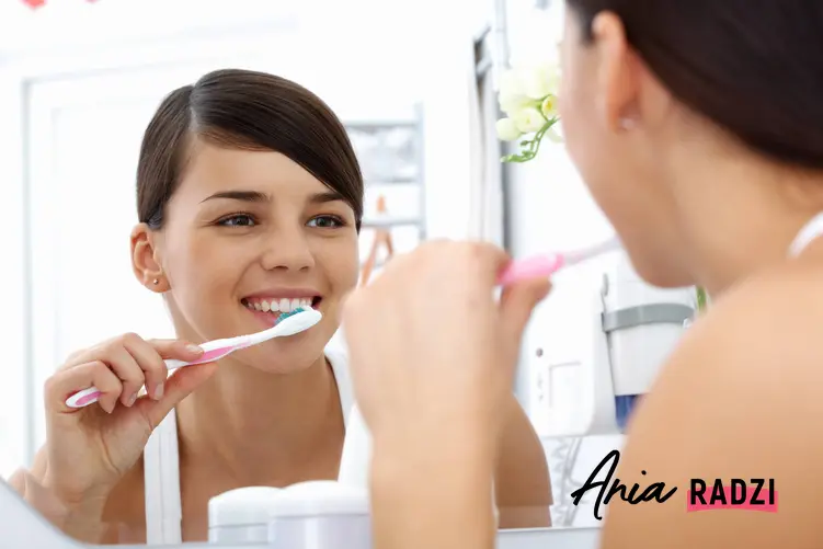 Kobieta myjąca zęby przed lustrem w łazience, a także soda na wybielanie zębów krok po kroku