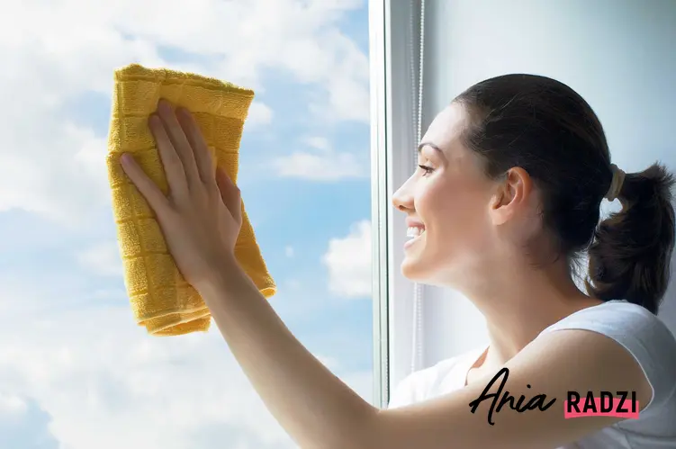 Kobieta myjąca szyby okien za pomocą ściereczki z mikrofibry. Ścierki i ściereczki do mycia okien polecane na rynku.