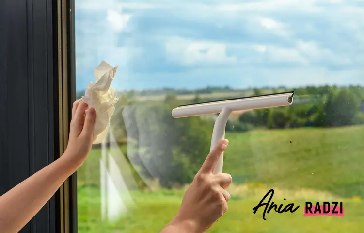 Kobieta myjąca okna specjalną ściągaczką do wody oraz mycie okna domowym sposobem.