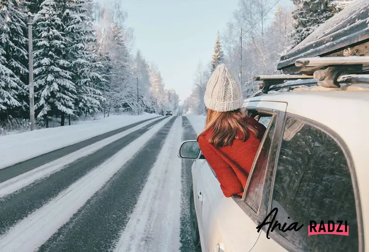 Kobieta jadąca samochodem w zimowych warunkach w czasie ferii