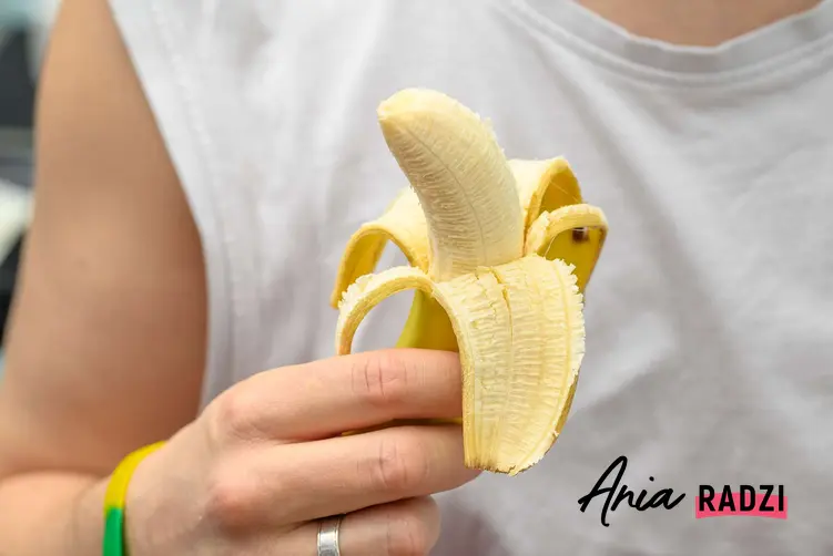 Mężczyzna trzymający obranego banana, który zamierza zastosować skórki od banana do innych celów