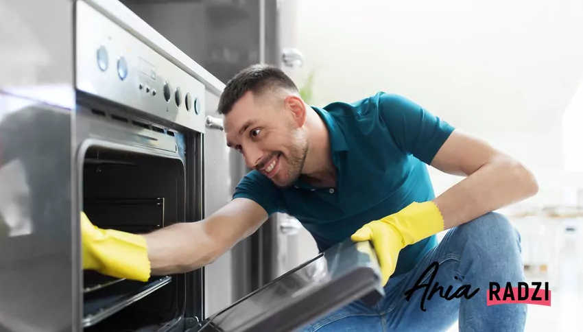 Poznaj sprawdzone sposoby na usunięcie przypalonego tłuszczu i brudu z piekarnika Mężcyzna czyści piekarnik