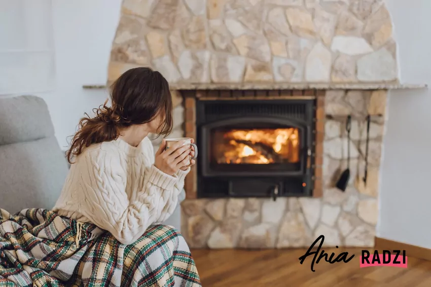 kobieta ogrzewa się przy kominku