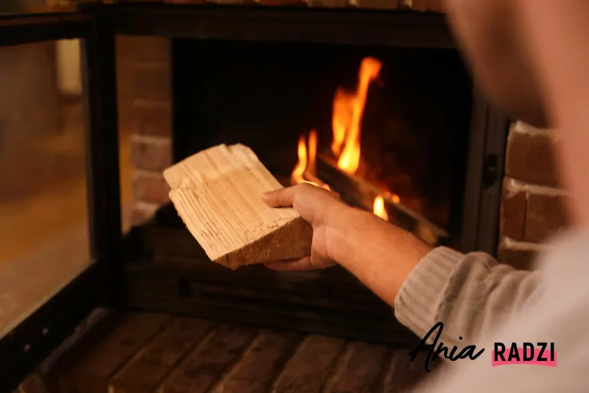 Nie wszystkie kominki są w stanie ogrzać cały dom mężczyzna dokłada drewno do kominka