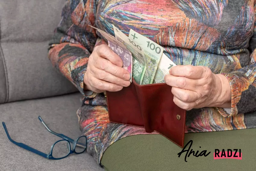 starsza kobieta wkłada pieniądze do portfela