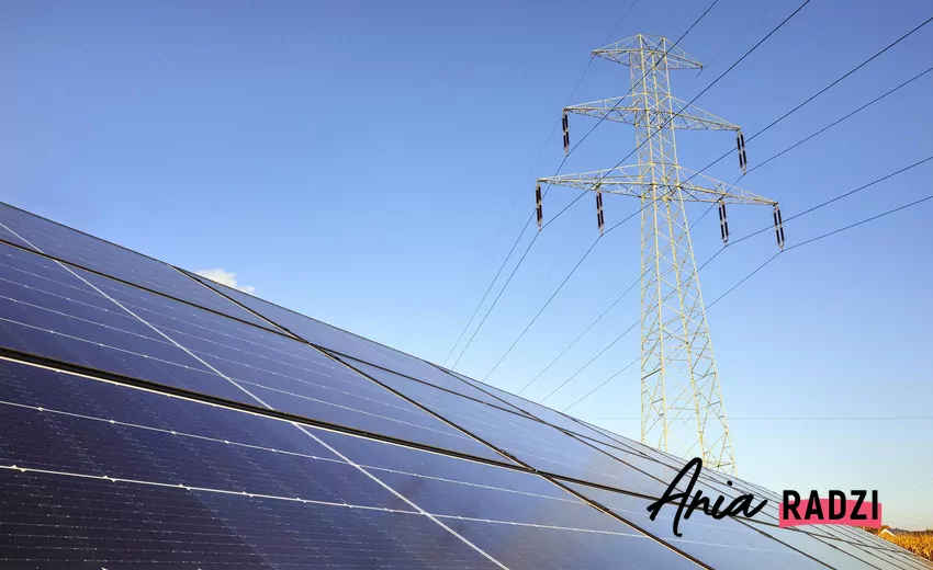 Panele fotowoltaiczne i sieć energetyczne na tle nieba