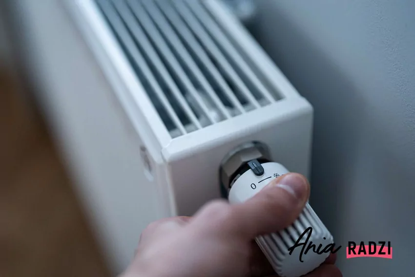 Dłoń regulująca pokrętło na grzejniku