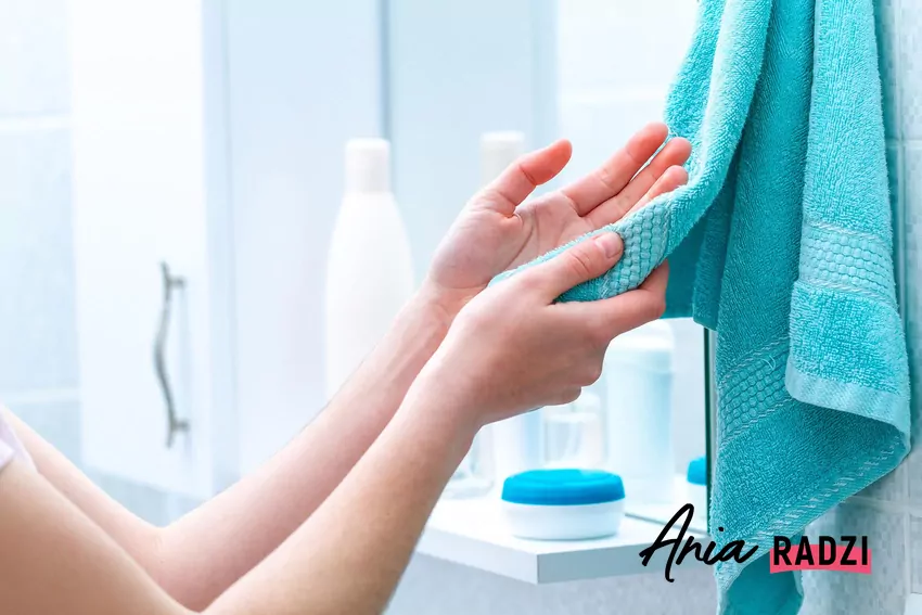 Ręczniki mogą zacząć brzydko pachnieć, jeśli nie będą odpowiednio prane Kobieta wyciera dłonie