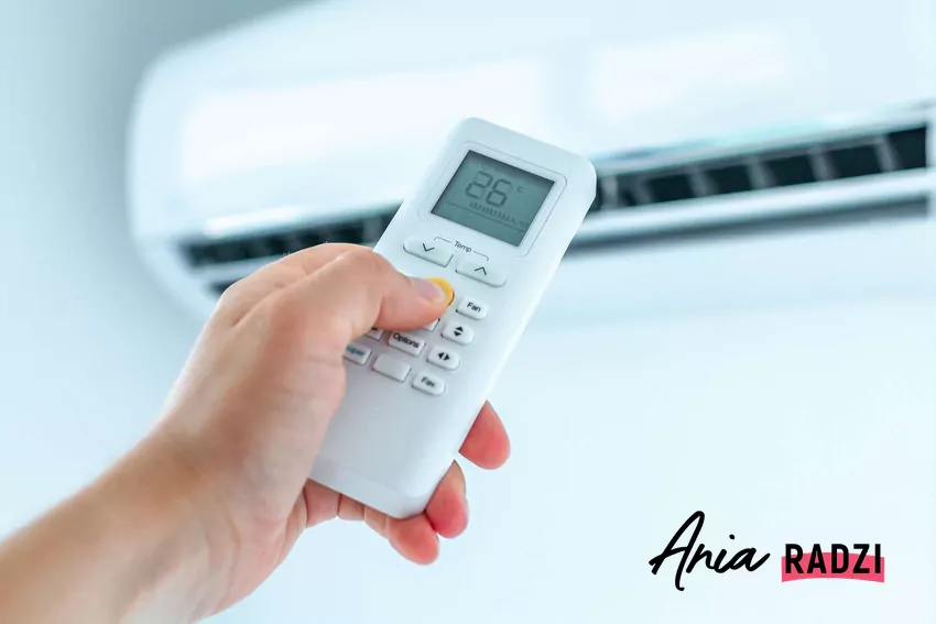 Dłoń trzymająca pilot do klimatyzatora
