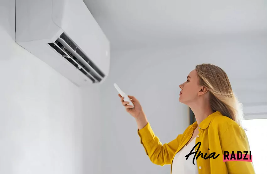 Kobieta uruchamia klimatyzator za pomocą pilota