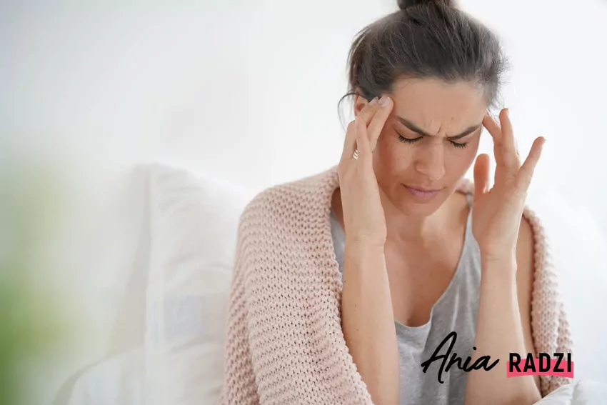 Kobieta trzyma się za skronie