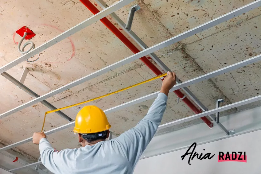 Mężczyzna montuje sufit podwieszany