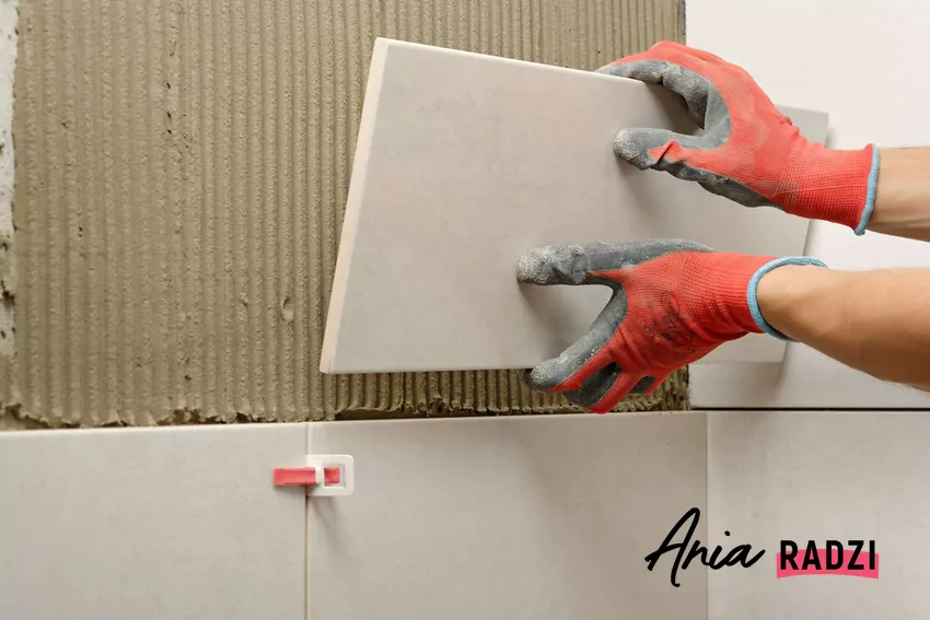 Niektóre remonty mogą być uznane za samowolę budowlaną i zgłoszone do inspekcji nadzoru budowlanego Fachowiec układa płytki na ścianie w łazience