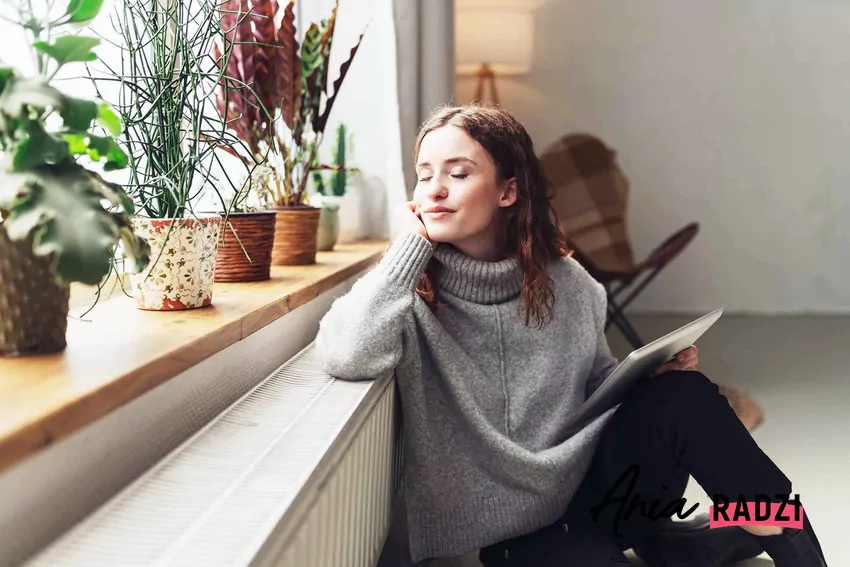 Kobieta siedząca przy kaloryferze