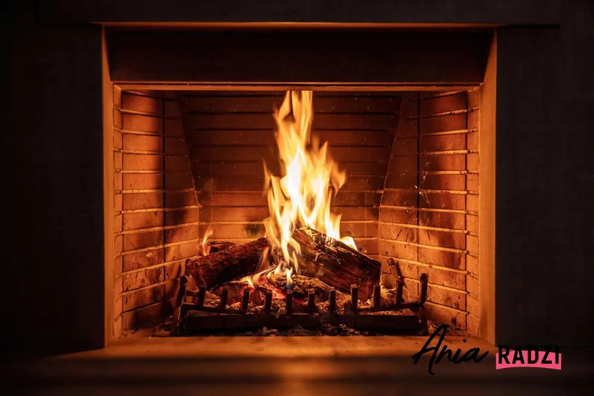 Rozpalony kominek z polanami drewna