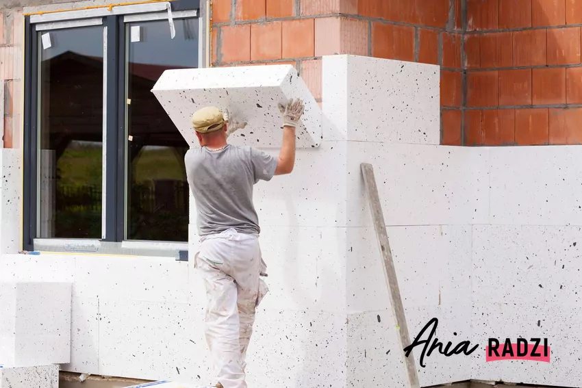 Mężczyzna wykonujący ocieplenie domu styropianem