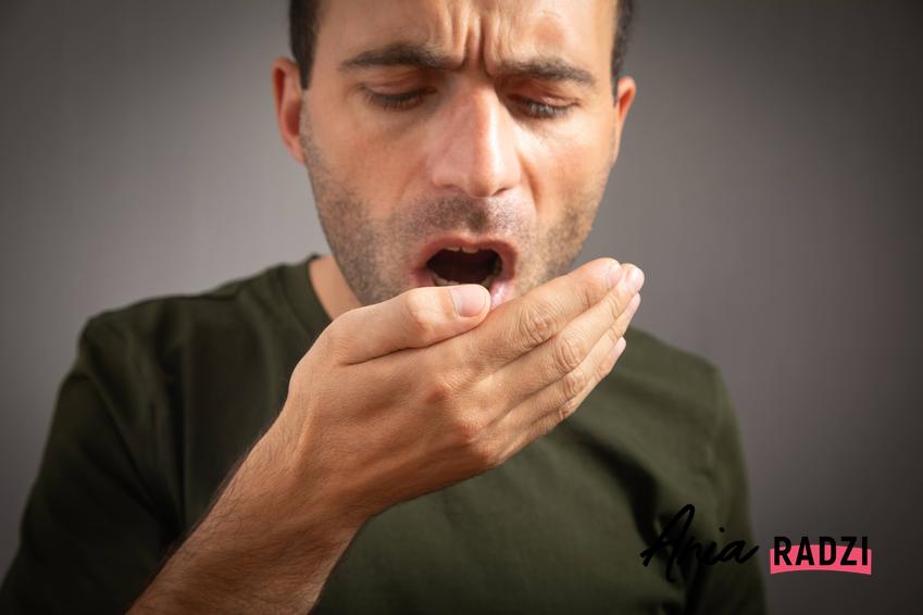 Mężczyzna czujący przykry zapach ze swoich ust, a także jak działa soda oczyszczona na nieprzyjemny zapach z ust
