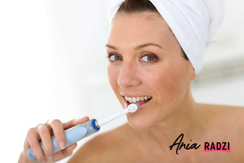Czyszczenie zębów szczoteczką elektryczną przez kobietę oraz porady, jak myć zęby szczoteczką elektryczną