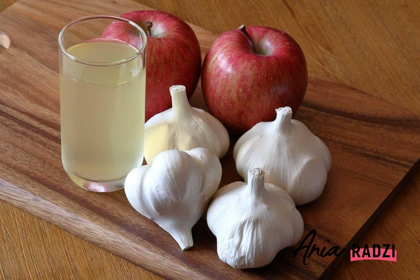 Czosnek i jabłka na desce oraz porady, jak zniwelować zapach czosnku i jak zneutralizować zapach czosnku z ust