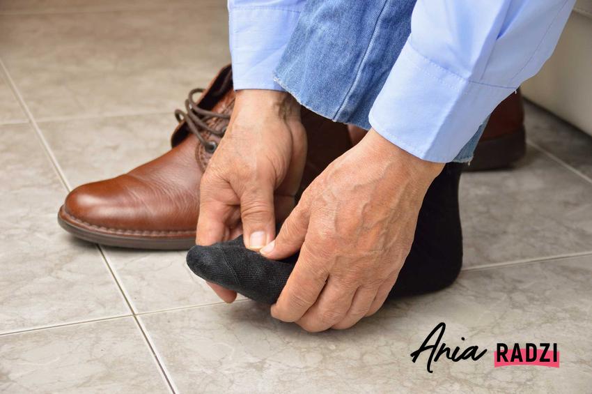 Mężczyzna z obolałymi stopami oraz porady, jak rozciągnąć buty i jak rozbić buty, gdy są za małe, domowe i sprytne sposoby