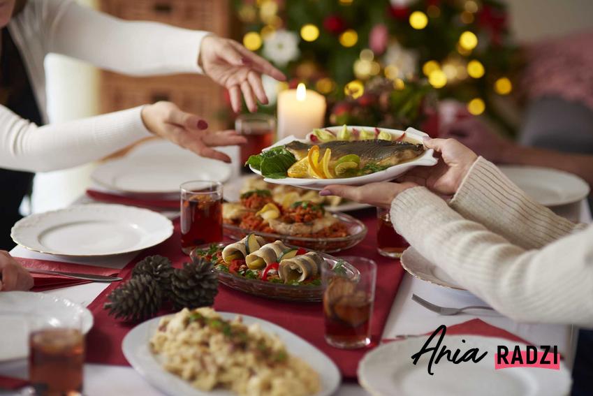 Potrawy wigilijne i stroik świąteczny na wiligijnym stole podczas świątecznej uczty oraz przepisy na najlepsze potrawy na Wigilię